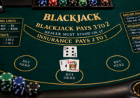 Blackjack table signage showing betting limits, payouts and dealer rules